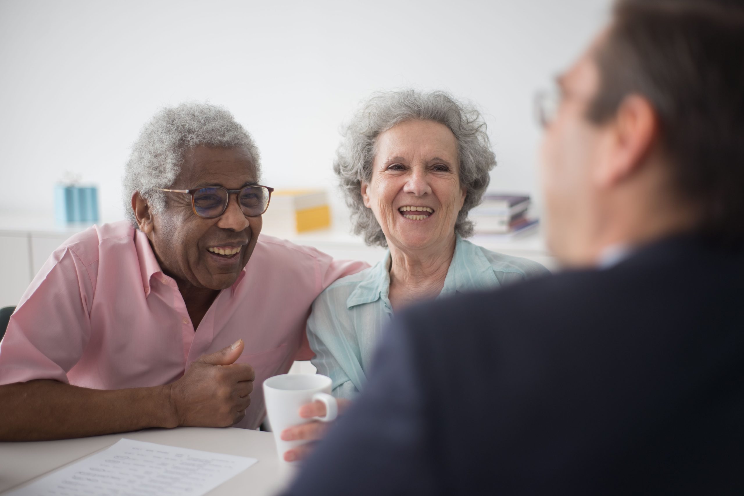 two seniors with mug laughing